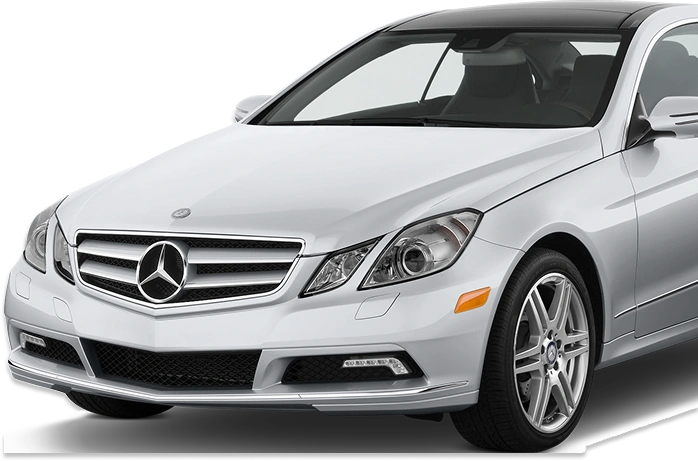 Front-side view of a white Mercedes-Benz coupe featuring a prominent chrome grille with the iconic star emblem, sleek headlights, and alloy wheels, showcasing a refined and sporty design.